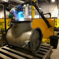A Kelair shop worker welds a diverter tee damper.